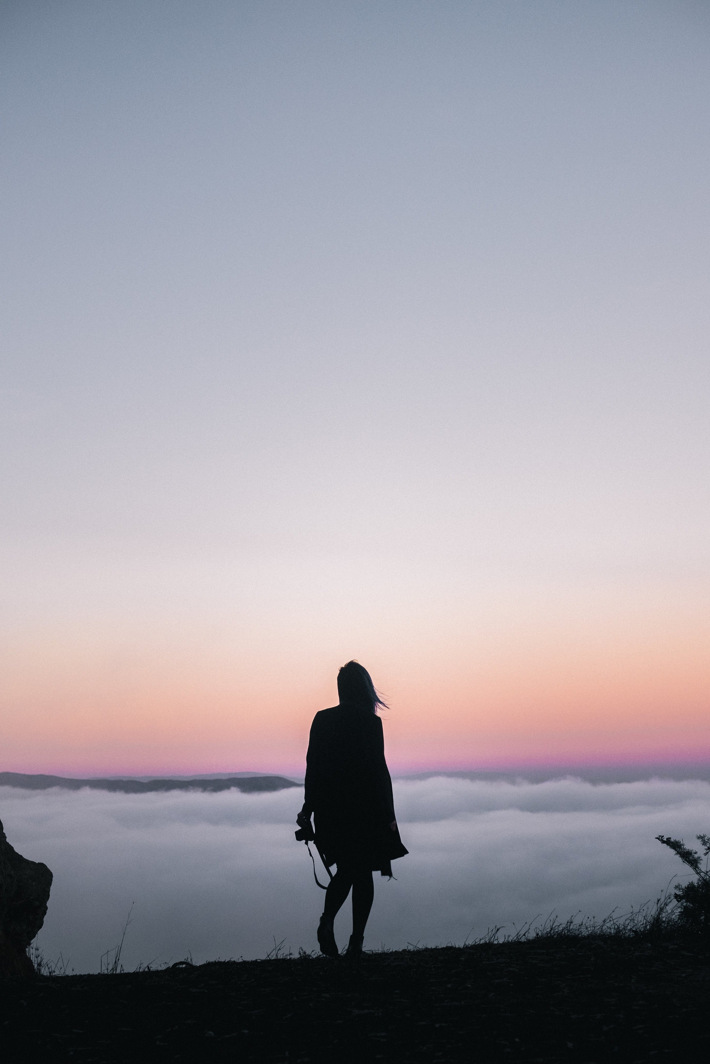 Standing on a hill overlooking a sea of clouds at sunset